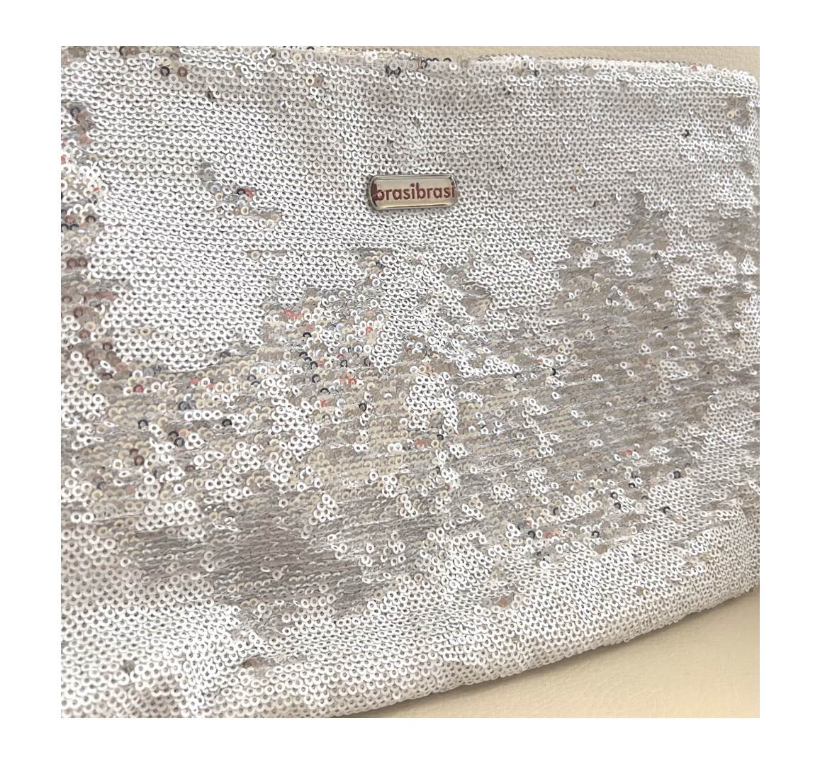 Glitzernde brasibrasi® Clutch oder Kulturtasche, komplett mit vielen weißen und silbernen Pailletten bedeckt. Teilweise umgedreht und silbern, erzeugen sie einen dynamischen Schimmereffekt. brasibrasi® Logo oben mittig.